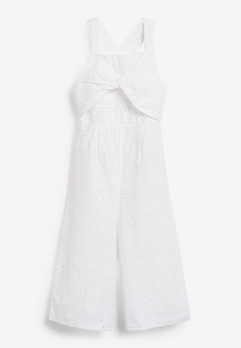 Combinaison blanche à jambes larges, réalisée en tissu texturé avec un motif découpé. Comprend un détail torsadé à l'avant et des bretelles ajustables.