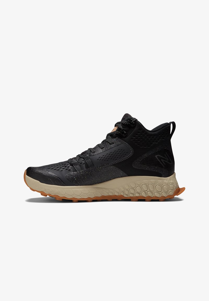 Black hiking shoe with a textured, breathable upper, reinforced toe, and a gum rubber outsole featuring a hexagonal pattern for traction.