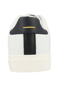 Baskets blanches avec une finition en cuir lisse, un talon noir et une bande verticale noire. Elles disposent d'une semelle en caoutchouc texturée et d'un accent jaune.