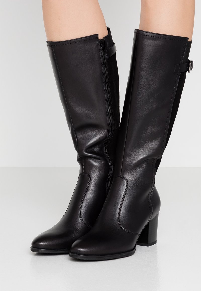 Bottes noires hautes jusqu'au genou en cuir lisse, bout rond, talon bloc et fermeture éclair latérale, avec des détails de couture subtils et une coupe ajustée.