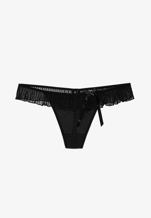 Schwarzer Tanga aus transparentem Mesh-Material, mit einem gerafften Rand, Satin-Schleifendetail und einer glatten, nahtlosen Verarbeitung am Körper.