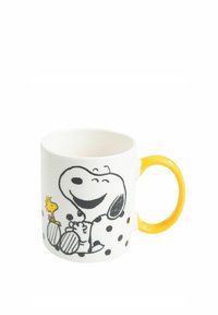 Tazza in ceramica bianca con un manico giallo, decorata con un design cartoon di Snoopy e Woodstock, impreziosita da punti e linee nere.