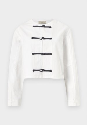 Λευκό cropped μπουφάν με μακριά μανίκια και τέσσερα μαύρα κουμπώματα με κόμπους μπροστά, στρογγυλή λαιμόκοψη, χωρίς γιακά.