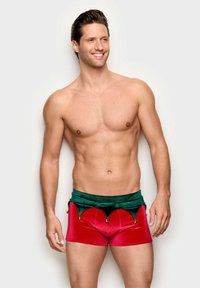 Røde fløjlsshorts med en grøn fløjlslinning med bølgekant og guldklokker. Designet med en tætsiddende pasform og blød tekstur.