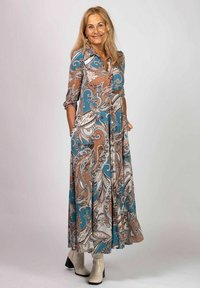 Lång klänning med paisleymönster i turkos, brunt och krämfärgat. Tillverkad i lätt tyg med knapp-up krage och sidofickor.