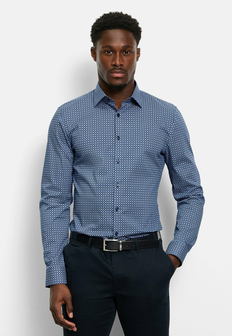 Himmelblaues Hemd mit Muster und kleinem geometrischen Design, langärmlig, mit Knopfverschluss und einem schwarzen Gürtel, der mit dunklen Hosen getragen wird.