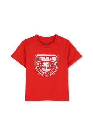 Rode korte mouwen peuter T-shirt met wit Timberland-logo en knoopsluitingen op de linkerschouder.