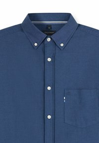 Marineblaue Hemd mit weißen Knöpfen, geknöpftem Kragen und einer einzelnen Brusttasche vor weißem Hintergrund.