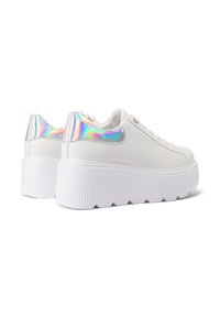 Baskets compensées blanches avec une semelle texturée et des accents irisés sur le talon, dotées d'un design à lacets et d'un supérieur en cuir synthétique lisse.