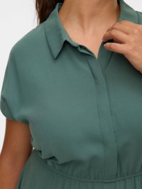 Zelené šaty s límečkem, krátkými rukávy, úzkým pasem, hladkým materiálem a jemným leskem, s předním knoflíkovým zapínáním.