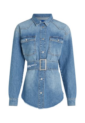 Ljusblå denimskjorta med lång ärm, två framfickor och midjebälte. Har en krage och en rak nederkant med lätt fransade kanter.