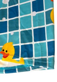 Blue and teal checkered fabric with a stitched hem, featuring a yellow rubber duck with an orange beak and black eyes in the bottom left corner.