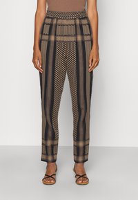 Mönstrade byxor med en blandning av mörkbruna, beige och svarta ränder. Elastisk midja, geometriska texturer och lös passform.