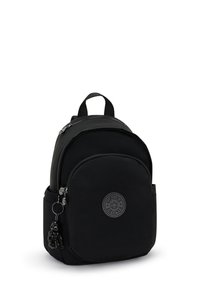 Sac à dos noir en tissu lisse, au design arrondi, doté d'une poche zippée à l'avant et d'un logo circulaire avec un pendentif attaché.