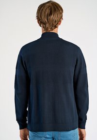 Dunkelblauer Strickpullover mit strukturierten Streifenmustern, geripptem Kragen, Bündchen und Saum sowie einer taillierten Passform.