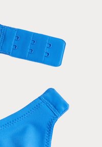 Tirantes de sujetador azul con ganchos ajustables, textura suave y costuras reforzadas. Presenta un diseño liso y un acabado mate.