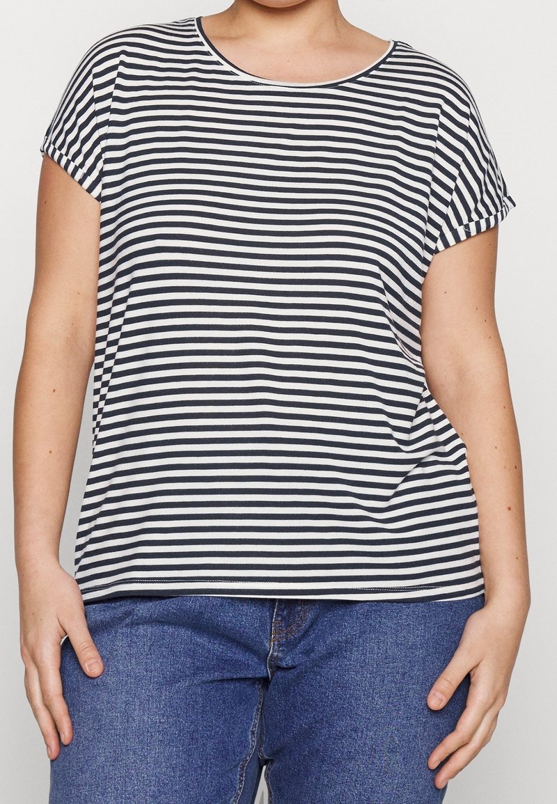 Camiseta de manga corta a rayas en azul marino y blanco. Escote redondo, corte relajado, tejido suave. Combinada con vaqueros azules para un look casual.