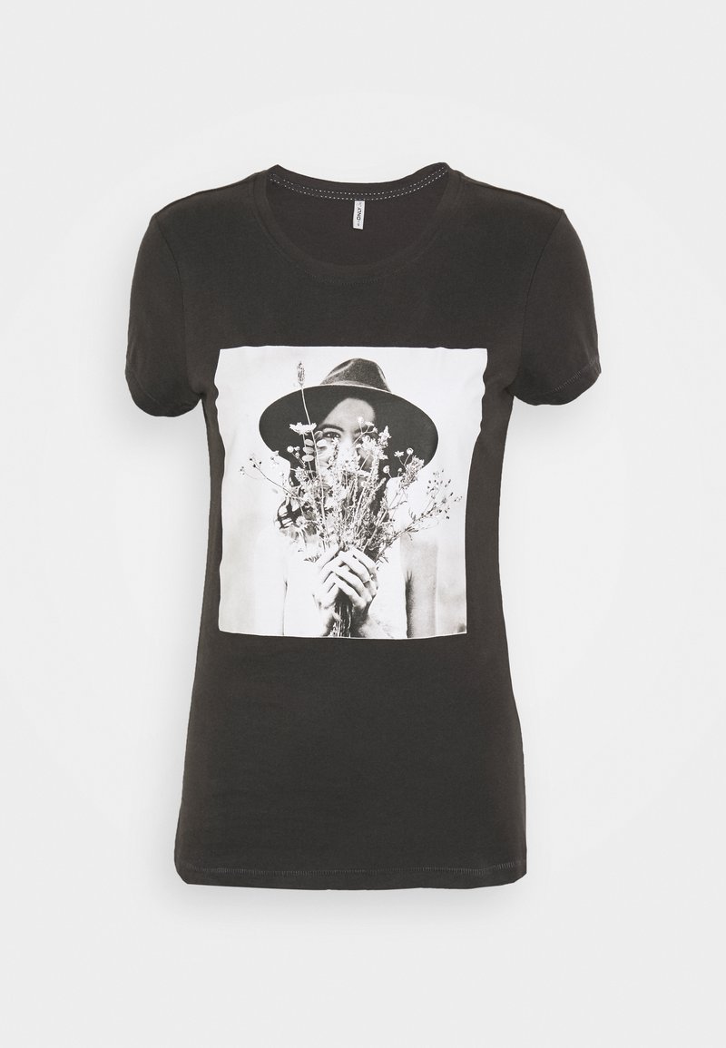 Camiseta negra de manga corta con un gran gráfico en blanco y negro de una persona sosteniendo flores y usando un sombrero de ala ancha.