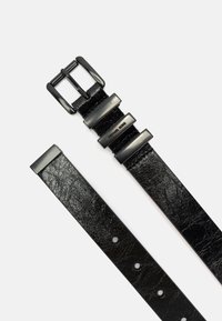 Black leather belt featuring a textured finish, silver-tone metal buckle, and adjustable holes for fitting. Brand name subtly embossed.