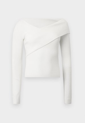 Biała prążkowana bluzka z długim rękawem, z odkrytymi ramionami i ukośnym zakładanym dekoltem na piersiach, tworząca strukturalną sylwetkę.