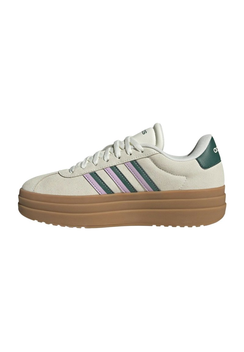 Sneakers with a cream suede upper, green and purple striped accents, and a thick tan rubber sole. Features a rounded toe and lacing system.