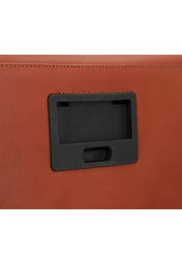 Prodotto in pelle marrone con un inserto rettangolare in plastica nera. Presenta cuciture visibili lungo il bordo, che migliorano la durata e il dettaglio del design.