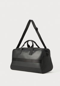 Black duffel bag made of smooth material. Features double handles and a detachable shoulder strap. Horizontal accents in matte finish.