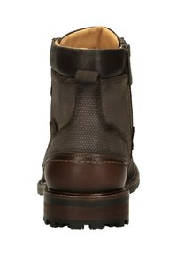 Bruine leren enkelboot met een gestructureerd oppervlak, een zijrits en een stevige zool met een gestreept patroon en gripnoppen.