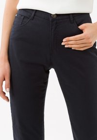 Marineblauwe katoenen broek in een blend met een rechte snit, vijf zakken en een sluiting met een knop aan de voorkant. Soepele textuur met minimale stikseldetails.