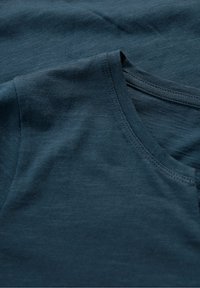 Tmavě modré bavlněné tričko s krátkým rukávem, kulatým výstřihem a hladkou texturou. Obsahuje jemné variace v vzoru látky.