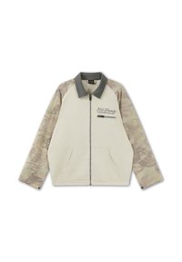 Beige Reißverschlussjacke mit grauem Kragen, camouflagegemusterten Ärmeln, Fronttaschen und "Ed Hardy 1974"-Stickerei nahe der Brusttasche mit Reißverschluss.
