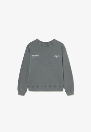 Sweat-shirt gris, en coton doux, col rond, manches longues, poignets et ourlet côtelés, avec texte blanc et graphique d'aigle sur le devant.