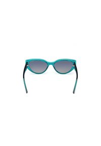 Gafas de sol turquesas con lentes gris degradado, forma de ojo de gato y puntas negras. Presentan un acabado brillante y herrajes metálicos.