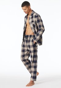 Pigiami da uomo a quadri in beige, blu navy e grigio. La camicia presenta un design con bottoni, mentre i pantaloni hanno una vita elasticizzata e tasche.