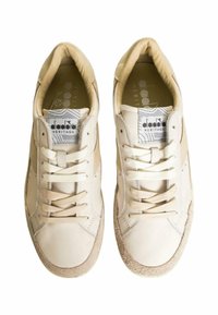 Sneaker in pelle avorio con punta in suede texturizzato e dettagli in pizzo beige. Presenta un'etichetta con il logo sulla linguetta e accenti cuciti.