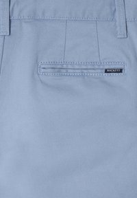 Helle blaue Stoffshorts mit einer Gesäßtasche, die über eine horizontale Nahtgestaltung verfügt, und einem schwarzen "HACKETT"-Label, das darüber angebracht ist.