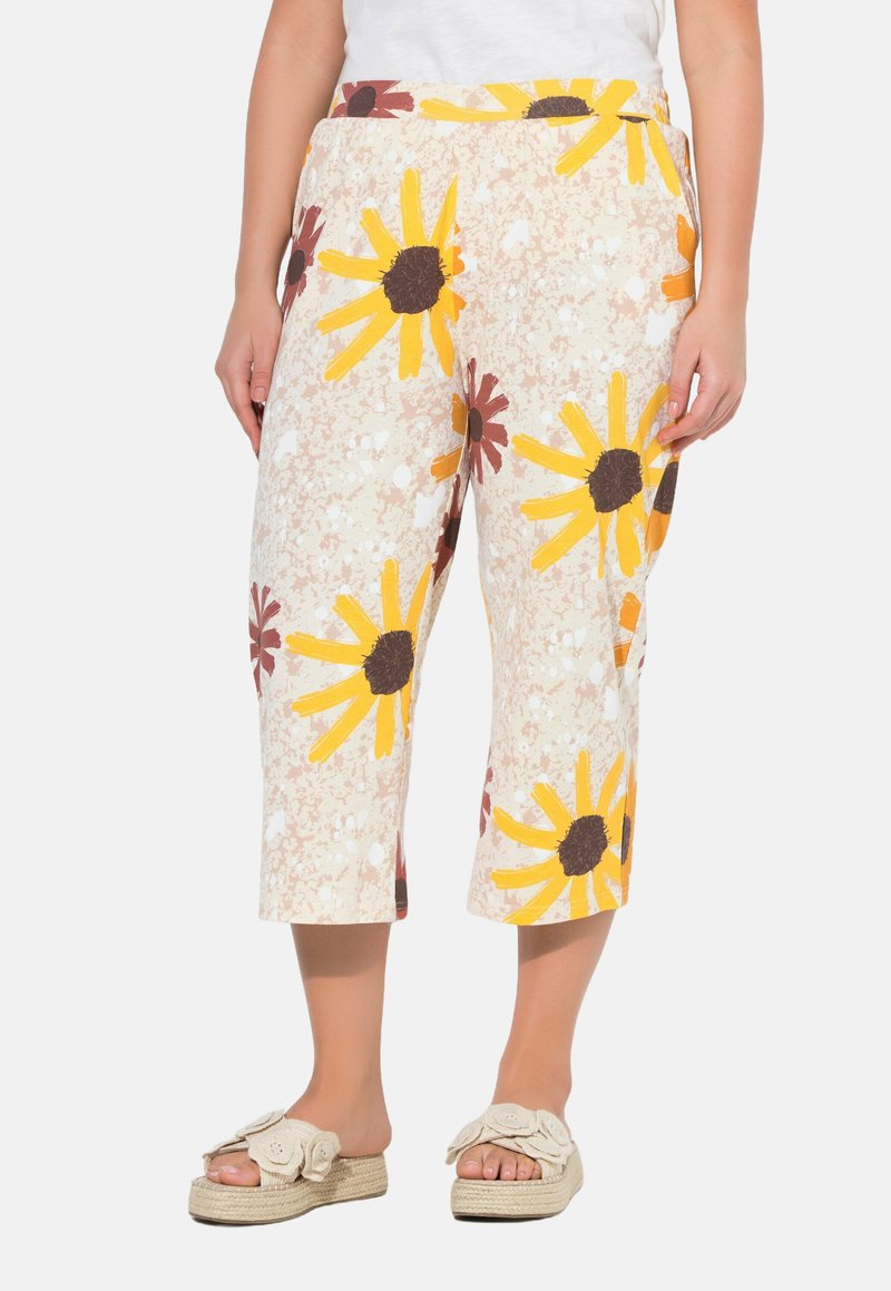Katoenen cropped broeken met een beige achtergrond en een heldere gele en bordeauxrode bloemenprint. Bevatten een elastische tailleband en hebben een casual pasvorm.