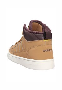 Brązowy wysoki sneaker z teksturowanej skórzanej zewnętrznej, miękkim kołnierzem i białą gumową podeszwą. Posiada logo w ciemnym fioletowym kolorze na pięcie.