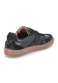 Czarno-skórzane i zamszowe sneakersy z okrągłym noskiem, brązową gumową podeszwą oraz sznurowanym zapięciem. Charakteryzują się delikatnymi różnicami w fakturze.
