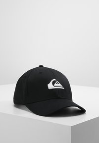 Svart baseballcap laget av stoff med en buet skjerm. Har et hvitt logoemblema på fronten og et ensfarget design.