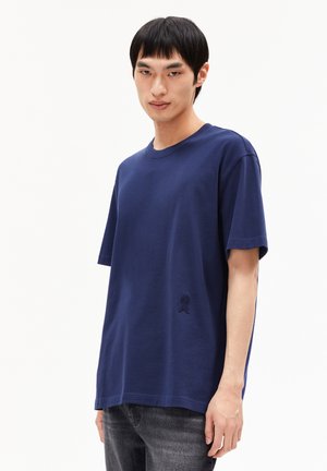 Marineblauwe katoenen t-shirt met korte mouwen, ronde hals en geborduurd detail op de borst. Heeft een loose fit en een zachte textuur.