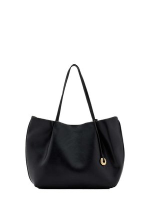 Bolso tote de cuero negro con dos asas para el hombro y un pequeño colgante circular dorado que cuelga de una fina cuerda de cuero.