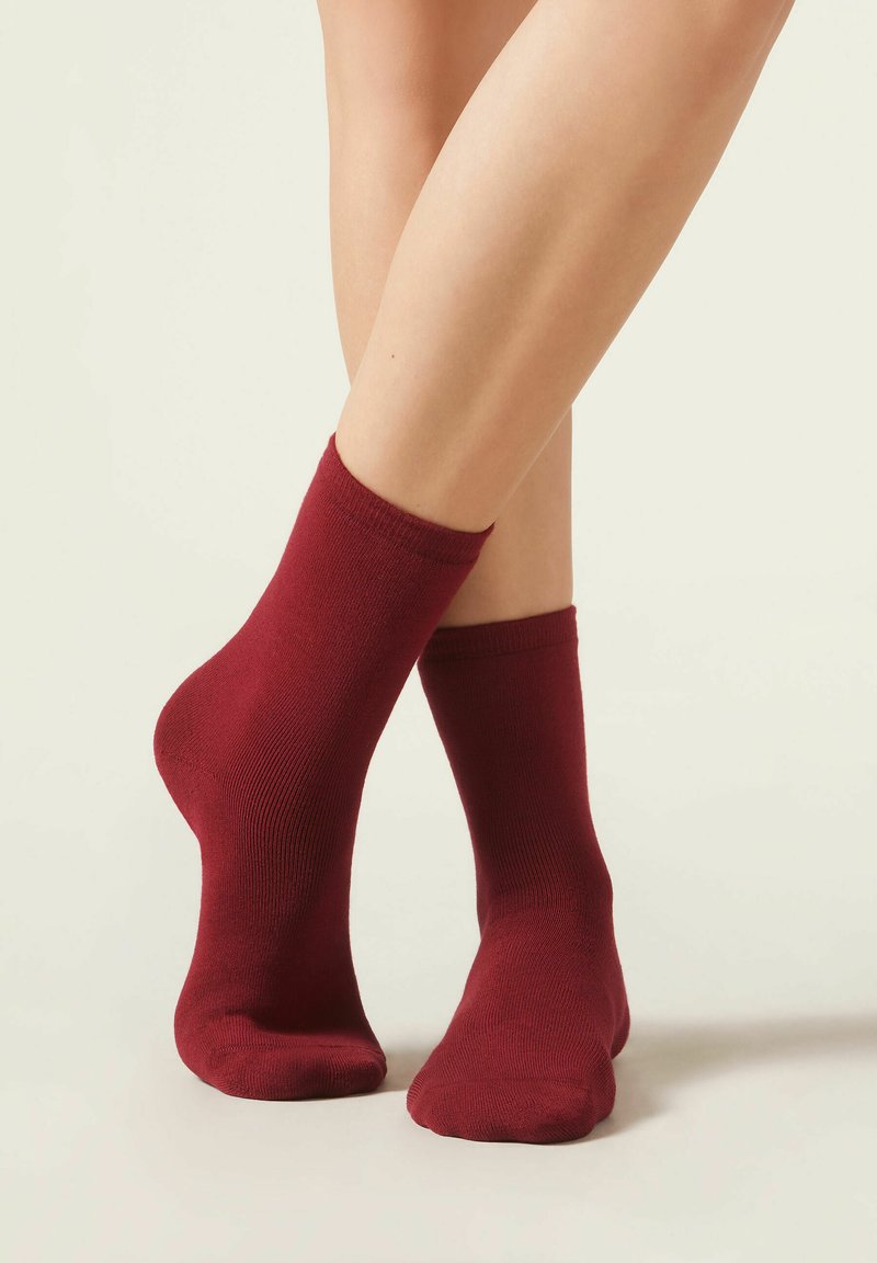 Burgundy crew sokker lavet af blødt materiale med en glat tekstur, med en ribbet kant og tæt pasform.