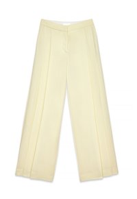 Pantalons larges de couleur jaune clair avec une texture lisse, dotés de plis sur le devant et d'une taille plate. Pas de matériel ou d'accents visibles.