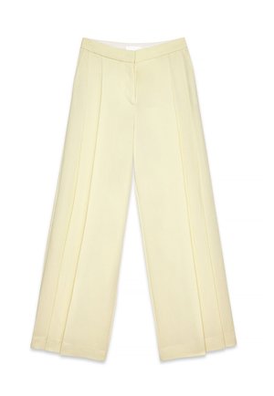 Pantaloni larghi di colore giallo chiaro con una texture liscia, dotati di pieghe frontali e una vita piatta. Nessun hardware o accentuazione visibile.