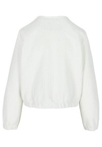 Kratka jakna iz teksturirane bele tkanine. Ima okroglo ovratnik, dolge rokave in elastičen pas za prilegljiv silhueto.