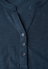 Maglietta henley blu navy con una fascia con quattro bottoni grigi, realizzata in cotone morbido e con un design testurizzato, leggermente a coste.