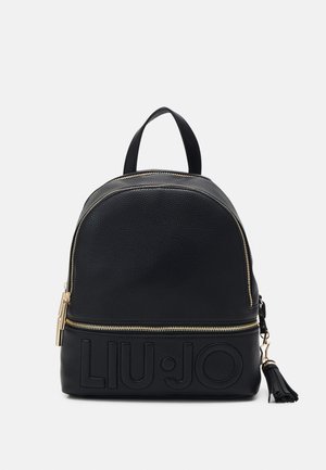 Schwarzer Leder-Rucksack mit runder Form, goldenen Reißverschlussdetails und eingeprägtem Logo an der Unterseite. Verfügt über einen Quastenakzent und einen oberen Griff.