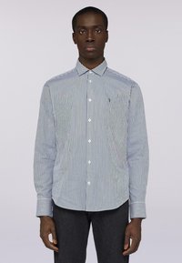 Pruhovaná košile na knoflíky v námořnické modři a bílé, s klasickým límcem, dlouhými rukávy a zapínáním na knoflíky. Hladká tkanina s rovnoměrnou strukturou.