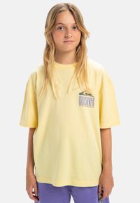 Gele oversized t-shirt van katoen, met een grafisch ontwerp op de borst met "Quiksilver." Korte mouwen en een ronde hals.